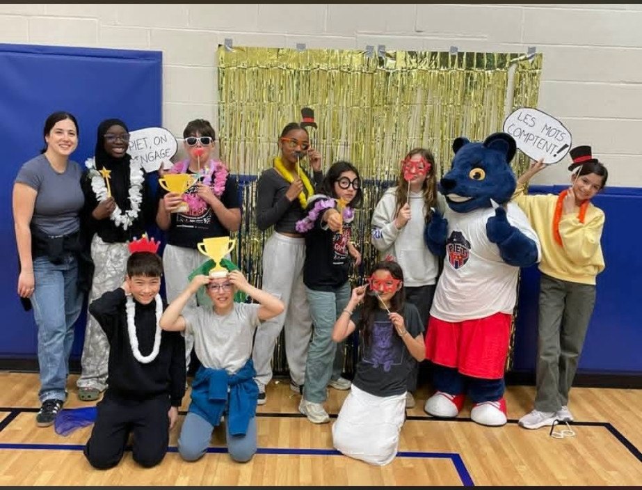 Les élèves de Pierre-Elliott-Trudeau posent avec la mascotte de l’école et les pancartes « PIET, on s’engage » et « Les mots comptent »